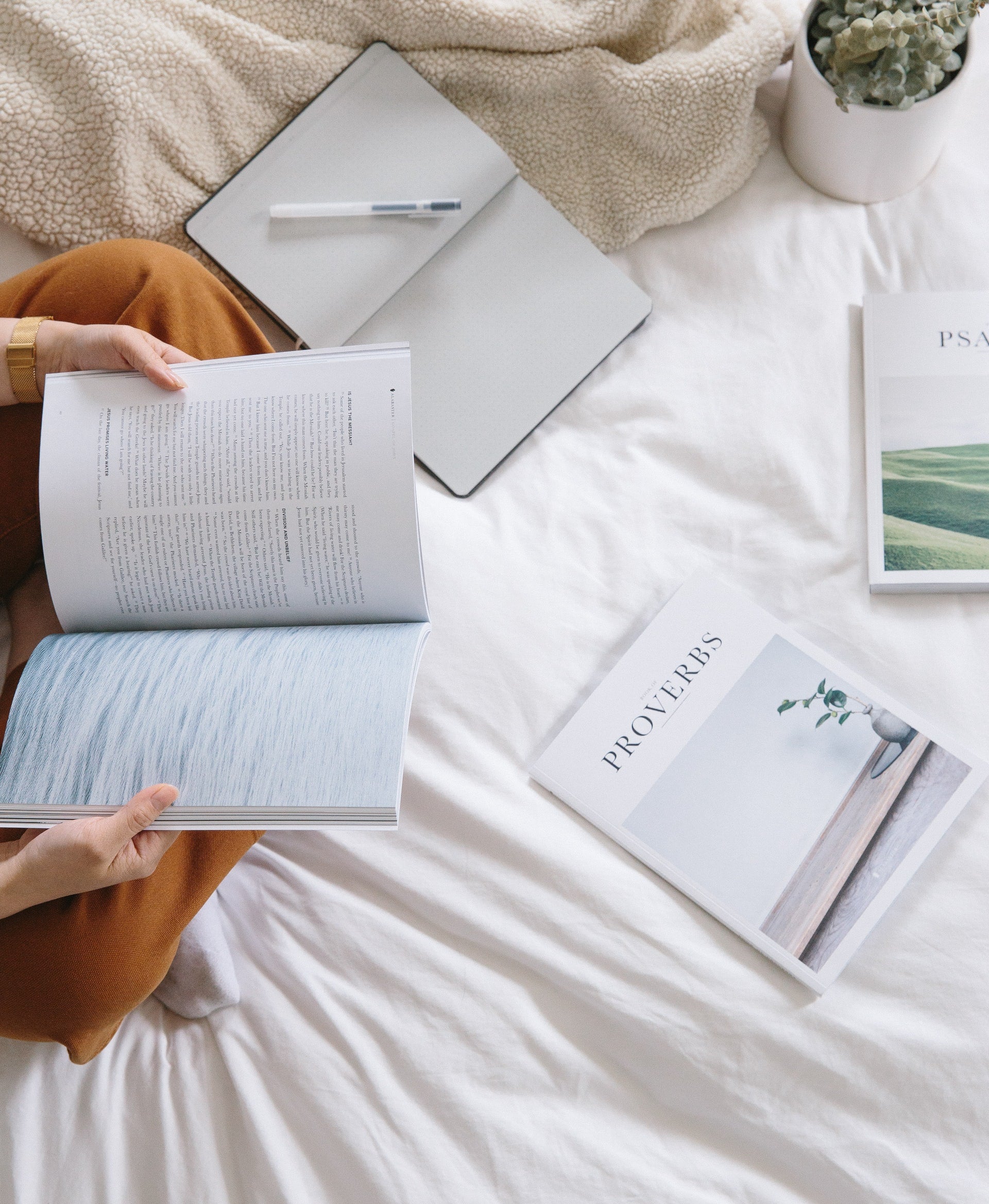 A person reading the Bible with an open notebook